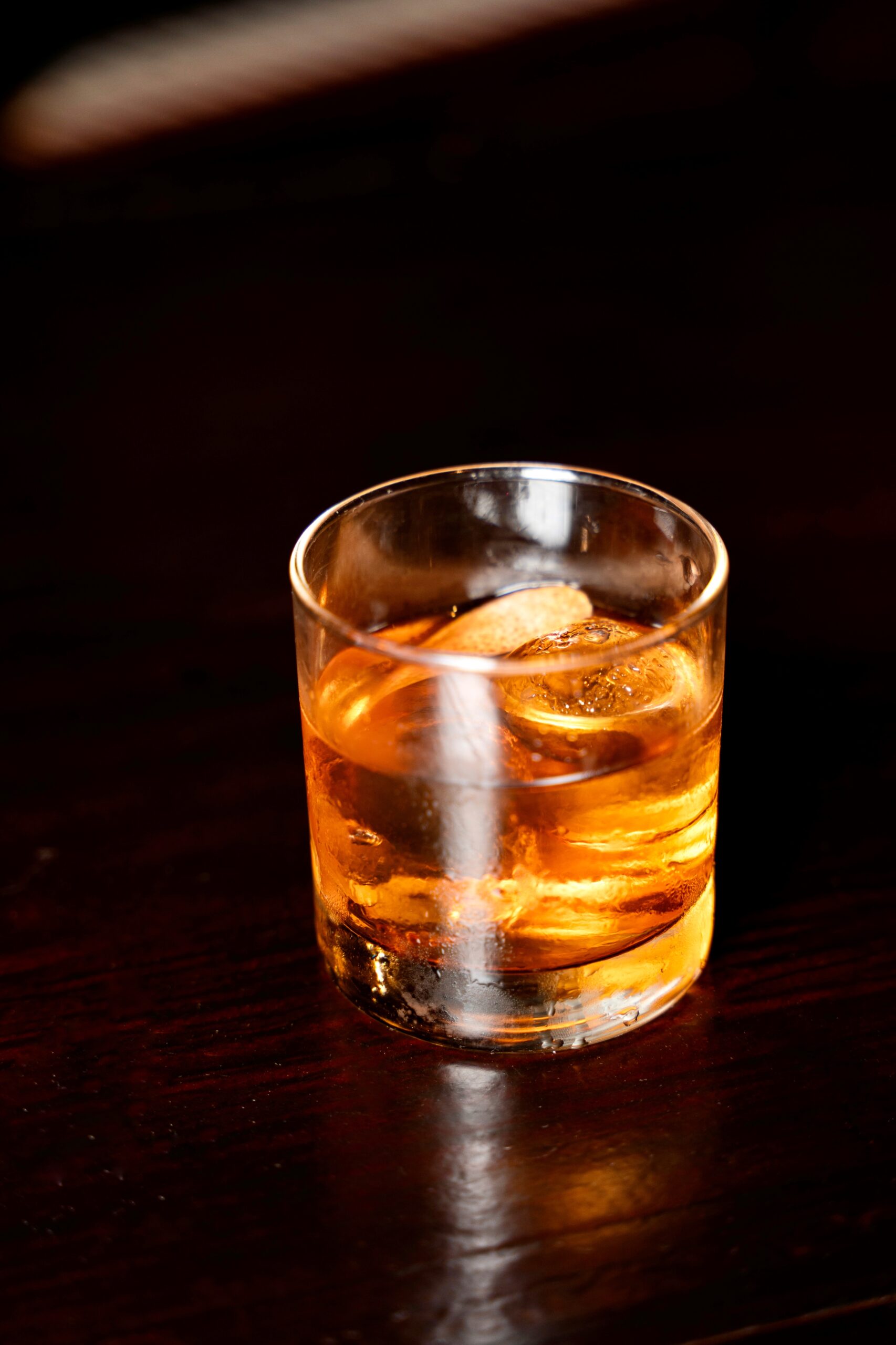 Close-up of ice and orange peel in a Champions Old Fashioned at Puttery.